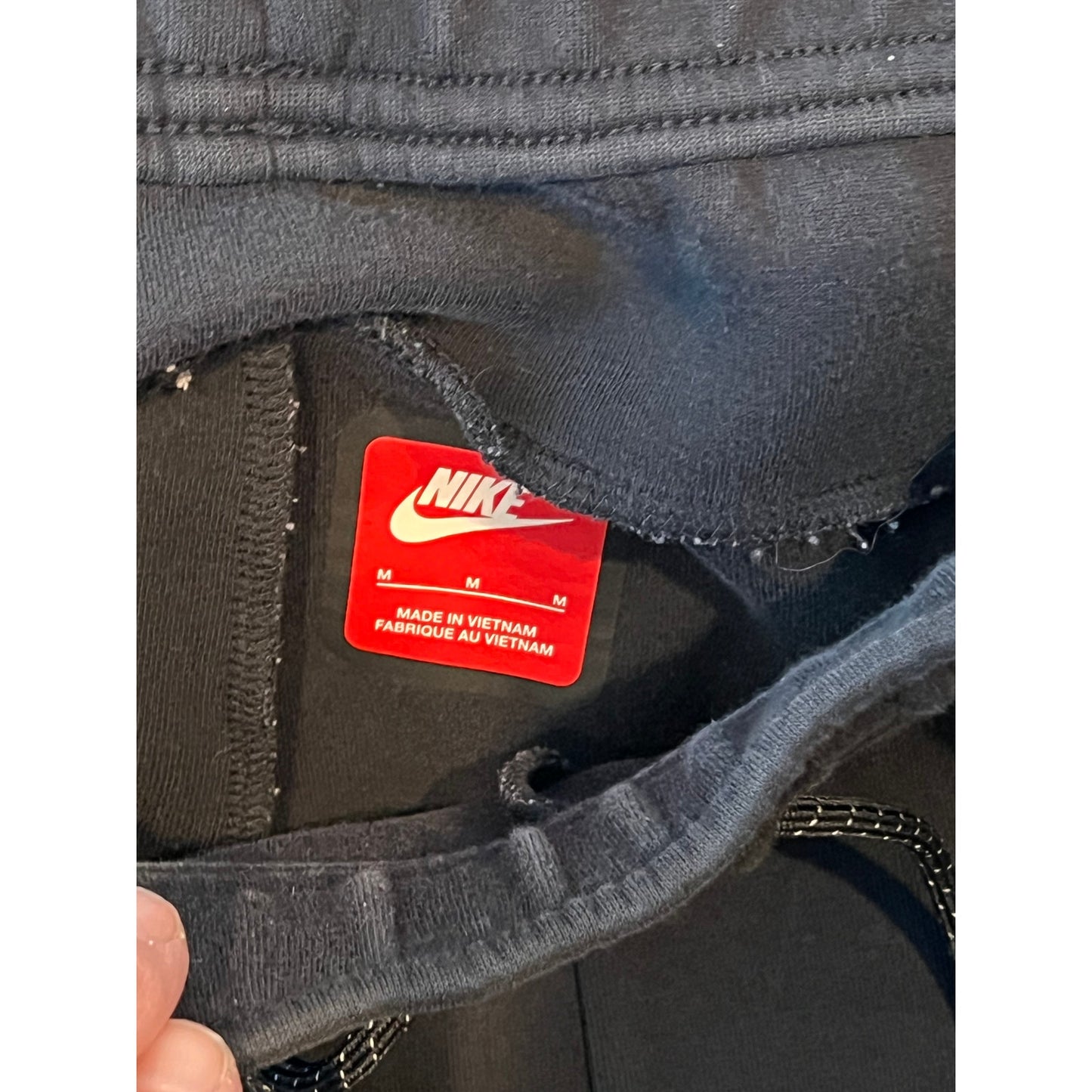Jogging Nike noir pour homme, coupe décontractée avec chevilles resserrées, taille M.